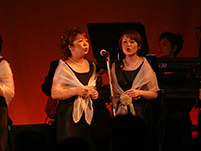 暗い中をキャンドルを手に入場するメンバー達